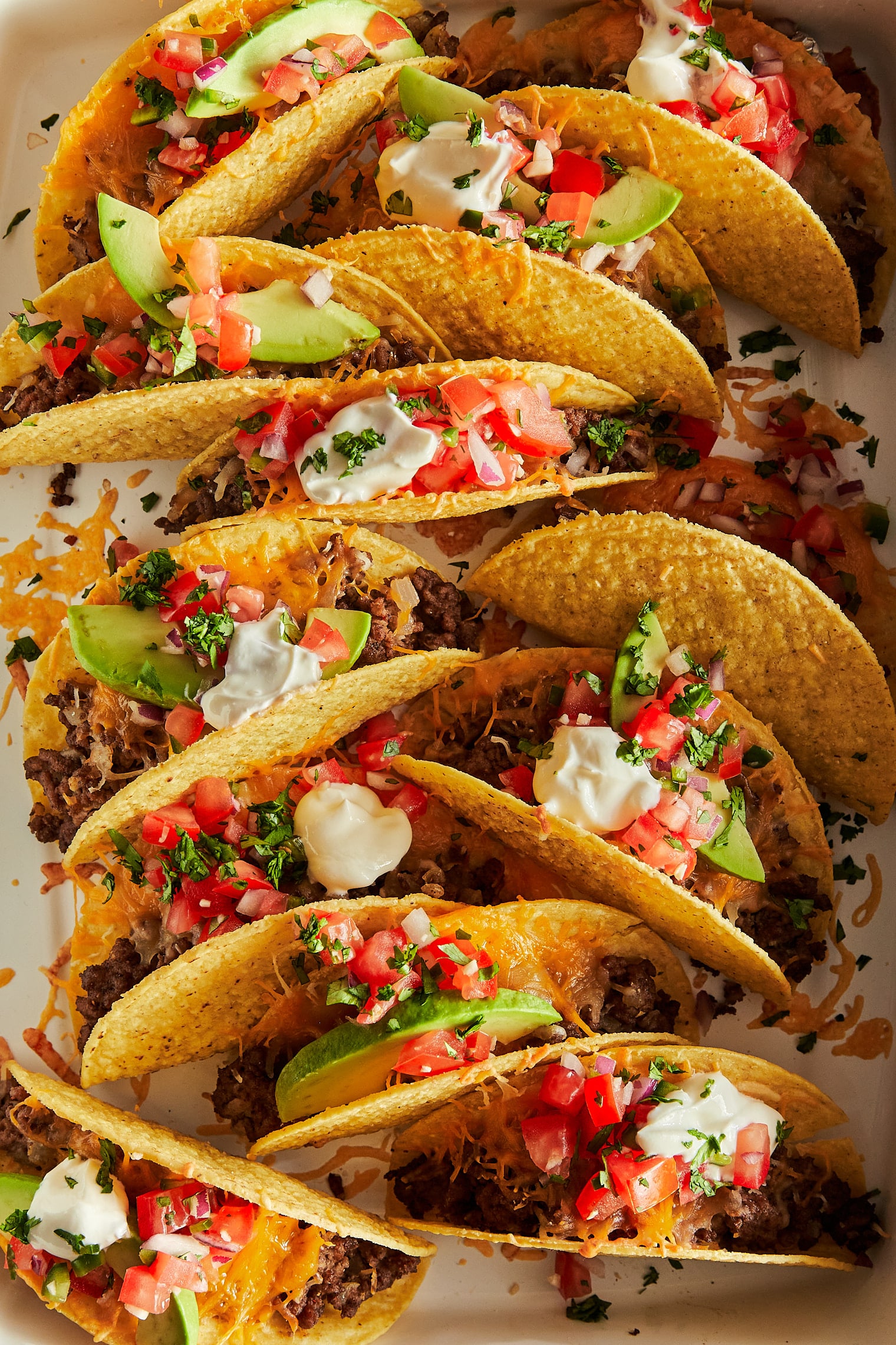 Baked Tacos - Crispy oven baked tacos! Made with hard taco shells, ground beef, taco seasoning, cheese, pico de gallo, sour cream + avocado!