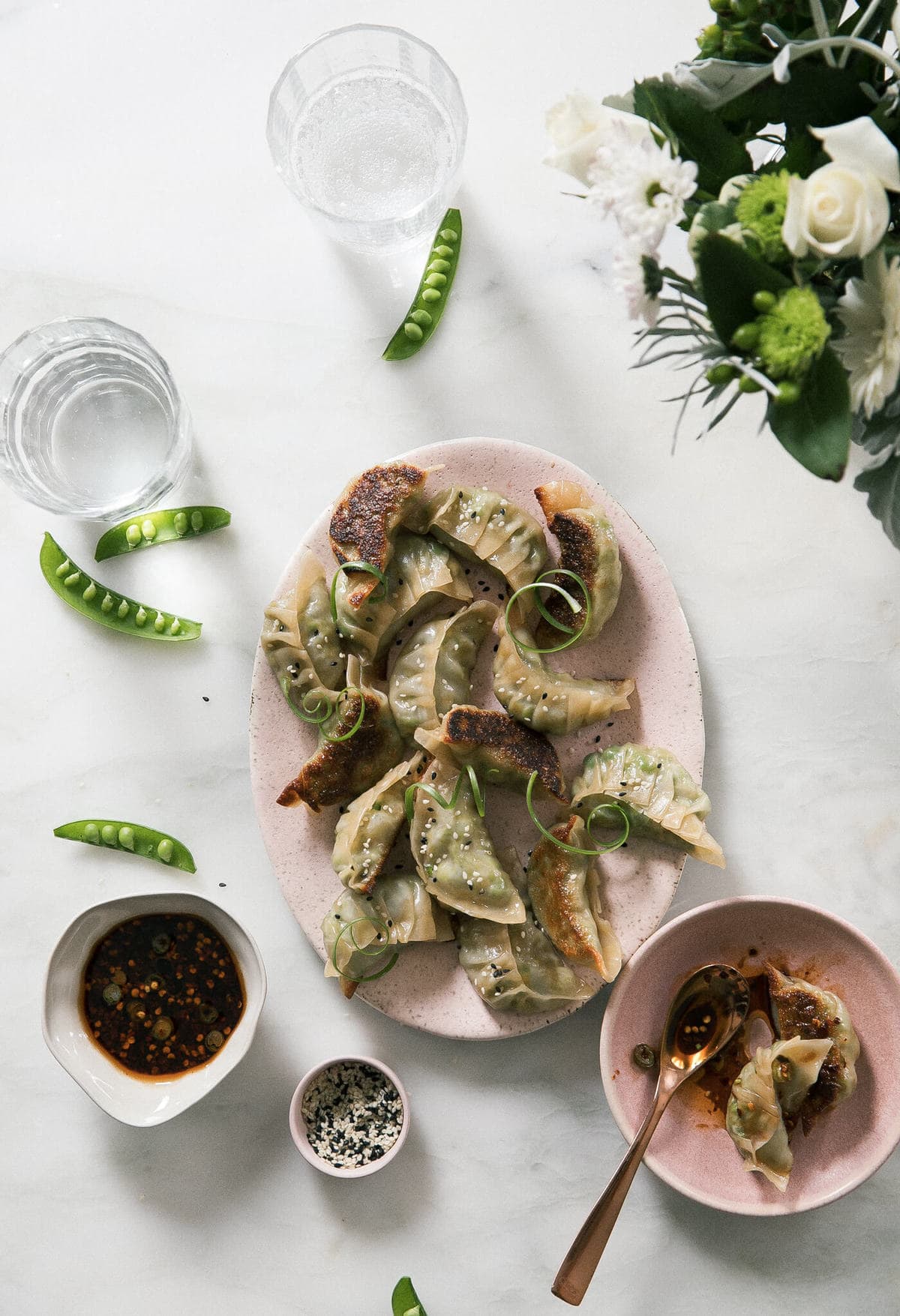 Potstickers on a plate with peas.