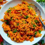 Square photo of overhead view of shredded carrot salad.