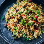 Chicken Fried Rice in a bowl with chopsticks and chilli oil for serving.