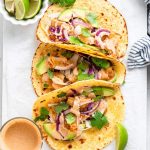 three folded crispy fish tacos in tortillas