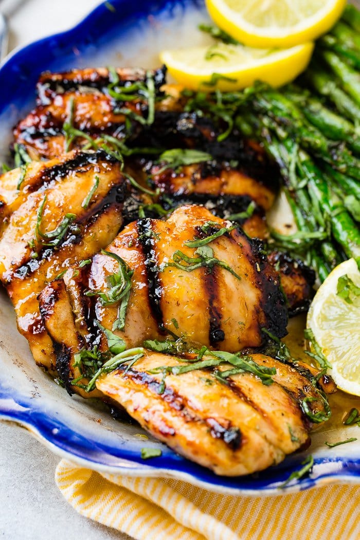 A photo of grill honey lemon basil chicken thighs with fresh basil chiffonade on top.