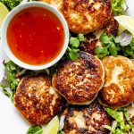 fish cakes on a platter with the herbal salad and thai sweet chili dipping sauce