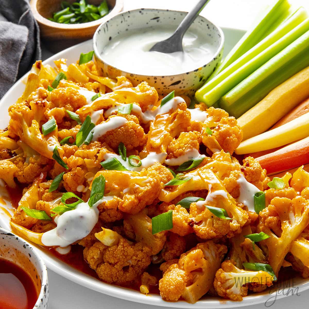 Air fryer buffalo cauliflower on a plate with ranch.