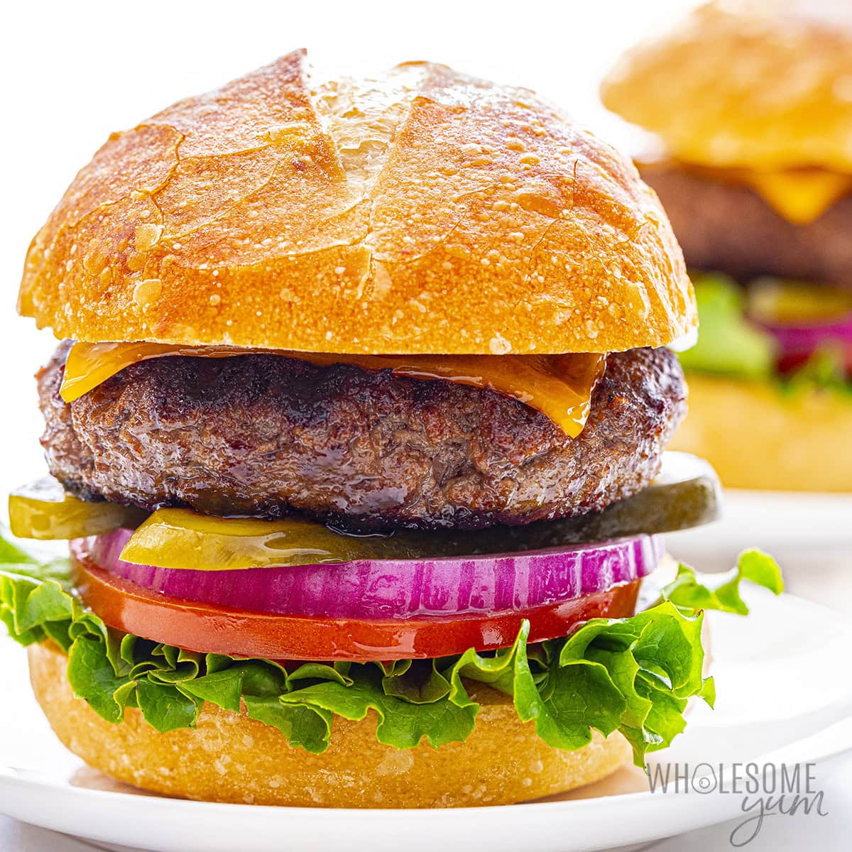 My best burger recipe makes these juicy burgers, shown on buns with fixings.