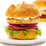 Salmon burgers on a bun with fixings.