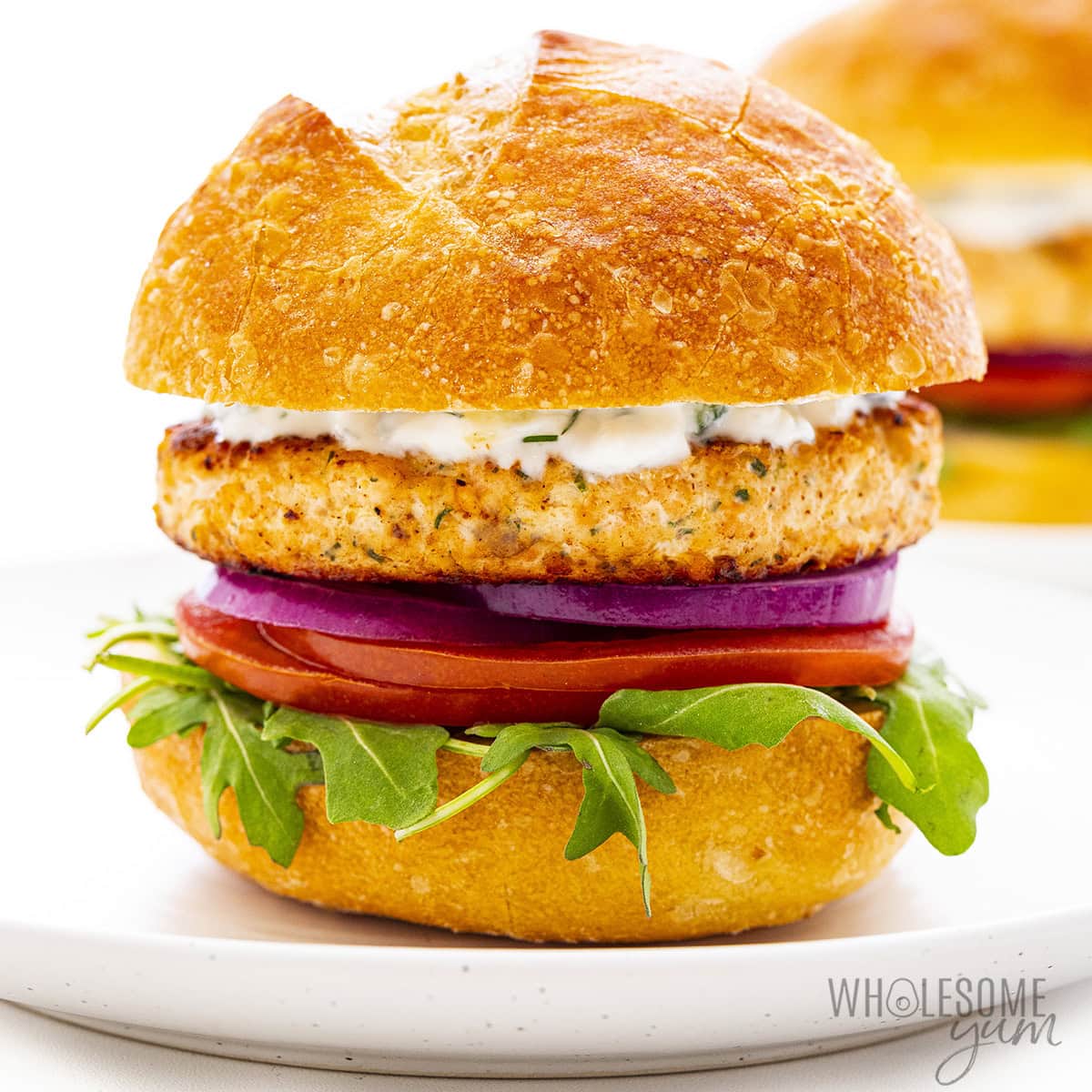 Salmon burgers on a bun with fixings.