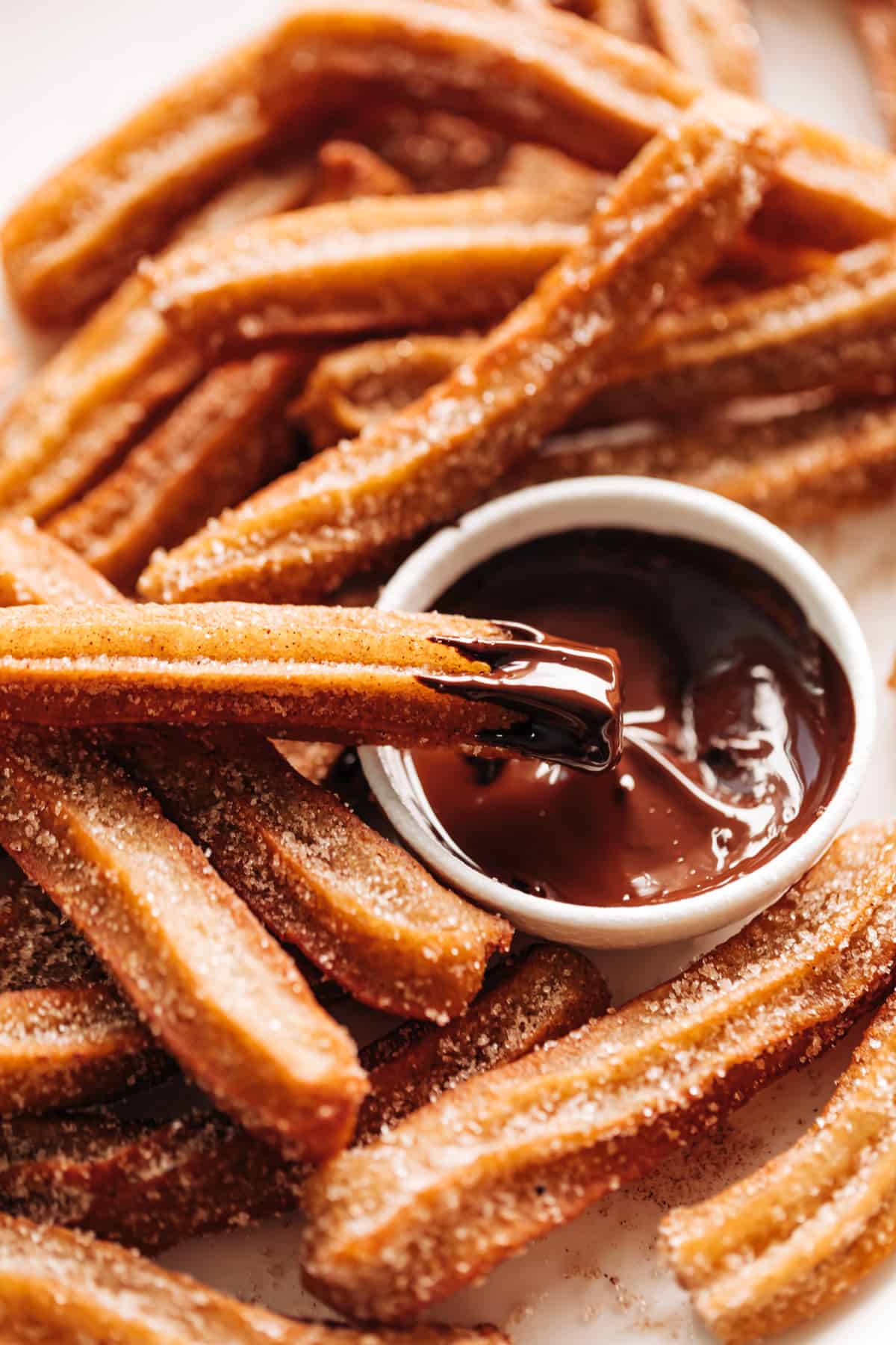 Churros dipped in a bowl of chocolate sauce