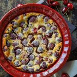 French custard dessert in a red dish with fresh fruit