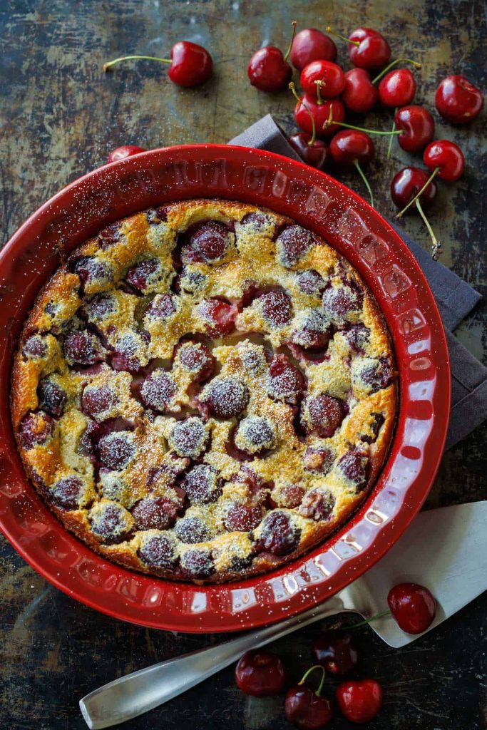 French custard dessert in a red dish with fresh fruit