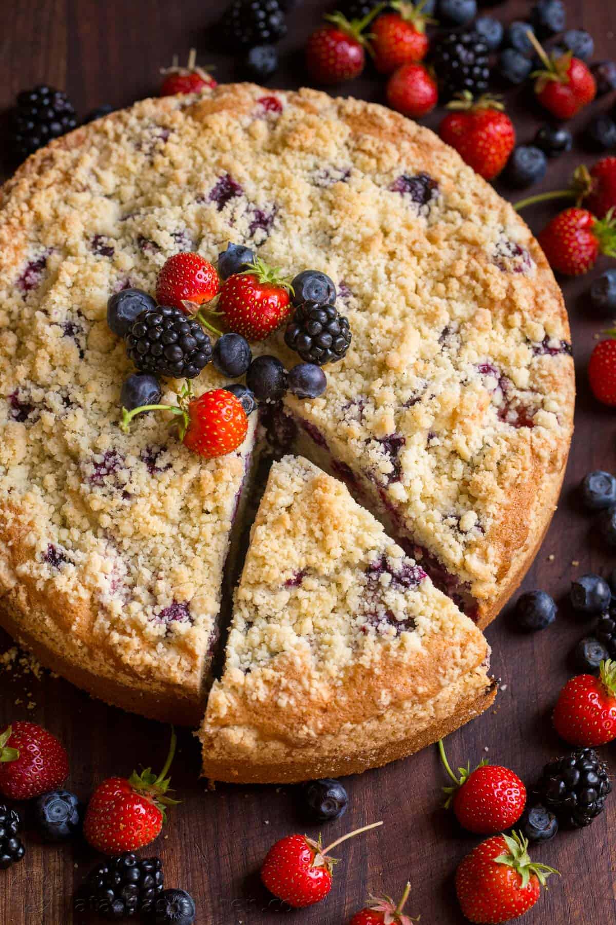 Triple Berry Cake Recipe sliced and garnished with berries