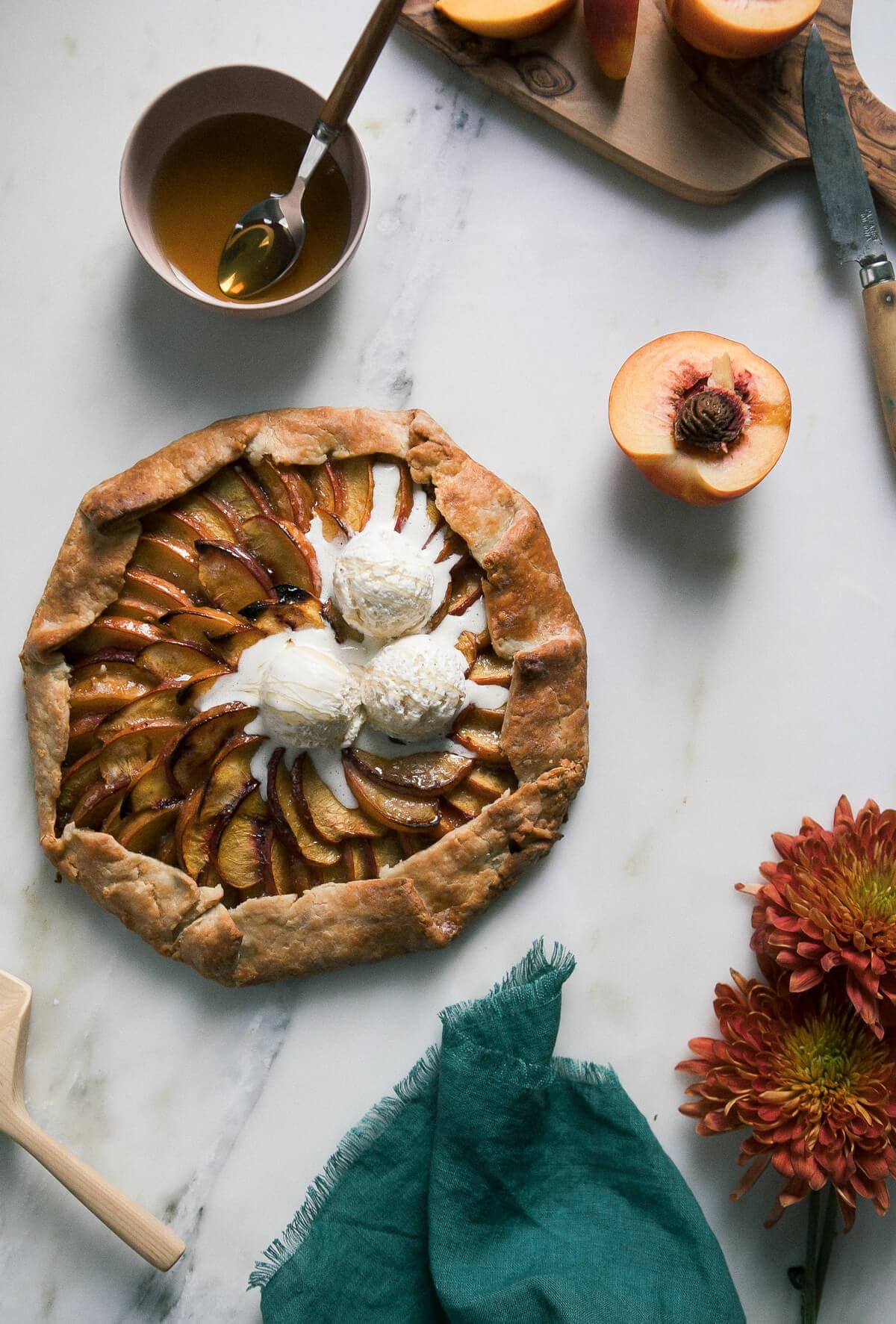 Peach Galette with Baklava Filling on a counter with scoops of ice cream on top.