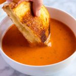 A bowl of Roasted Tomato Soup made with roasted tomatoes, basil, and garlic.