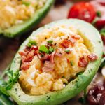 Soft scrambled eggs topped with crispy bacon and stuffed into halved, skinned avocados.