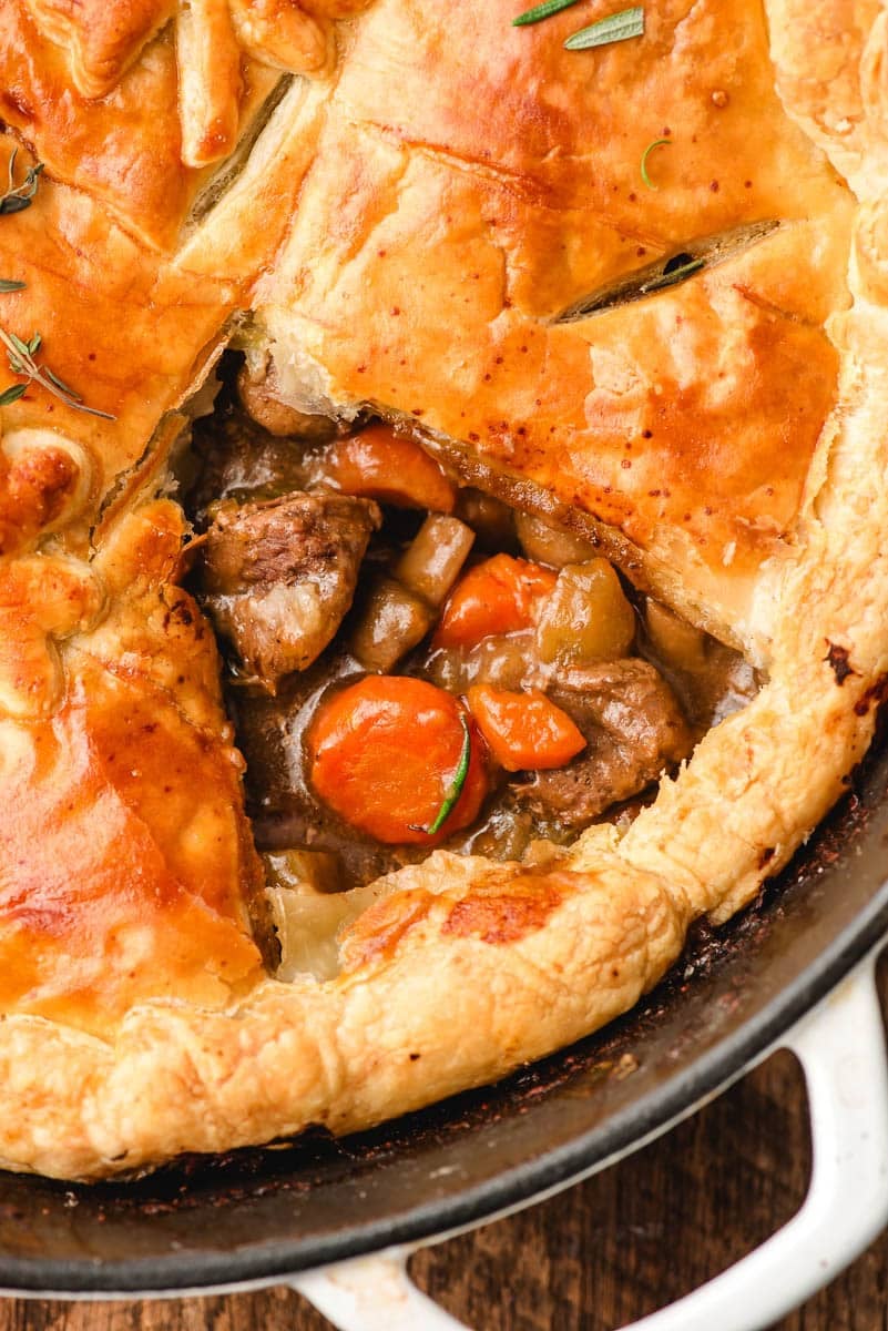 Pot pie with the crust taken off of a portion so you can see the beef and vegetable filling.