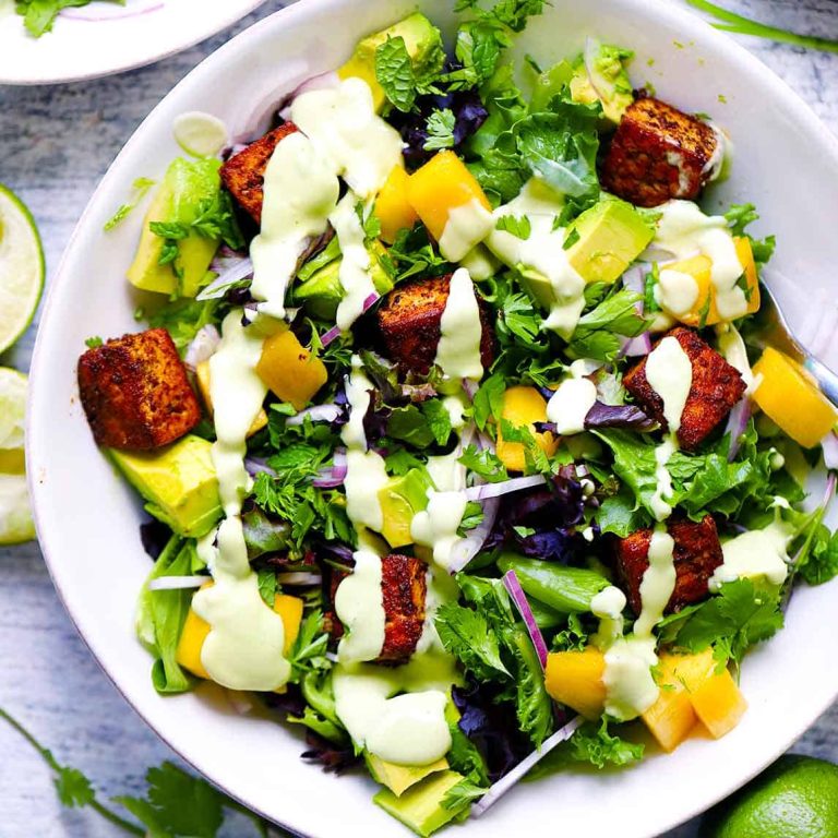 Square photo of a bowl of mango avocado salad with blackened tofu.