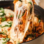 Scoop of one pot lasagna with lots of gooey, melty mozzarella cheese strings hanging down.