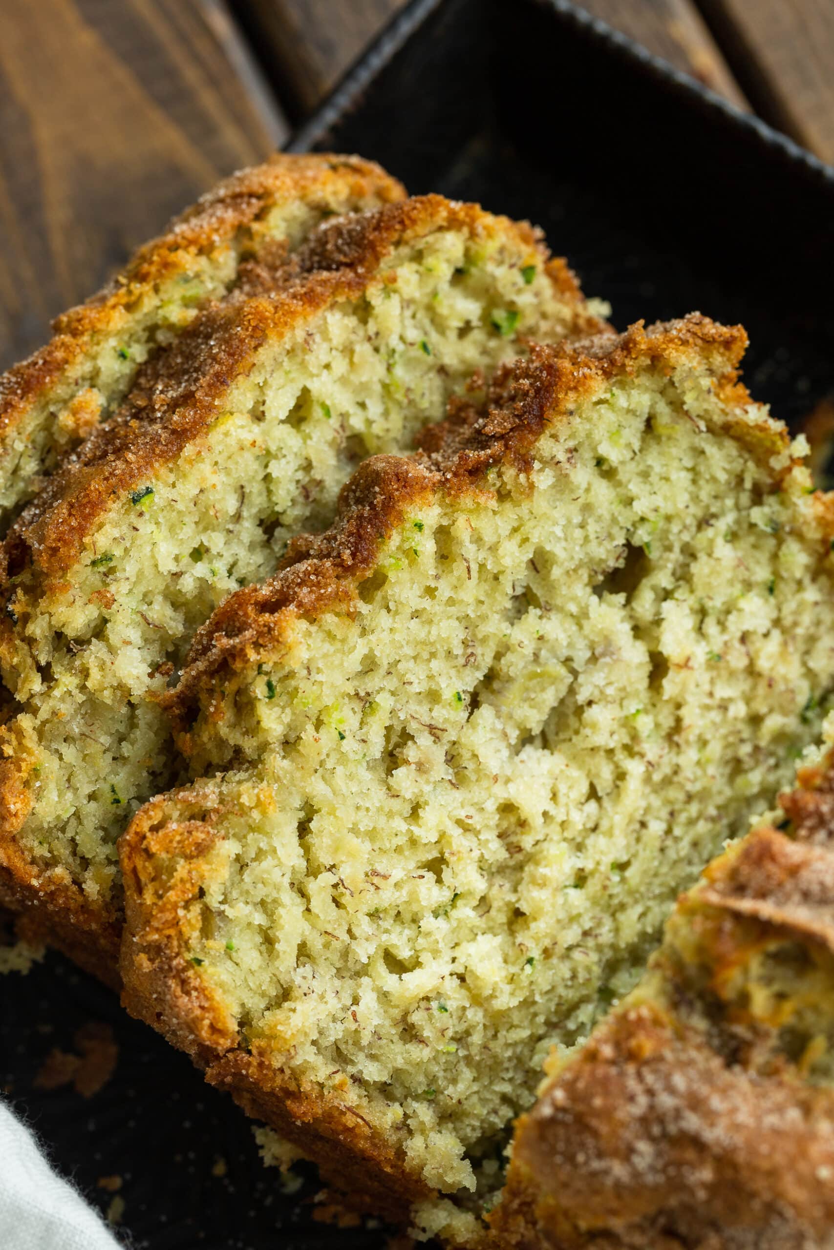 a photo of three slices of  zucchini banana bread leaning on each other.