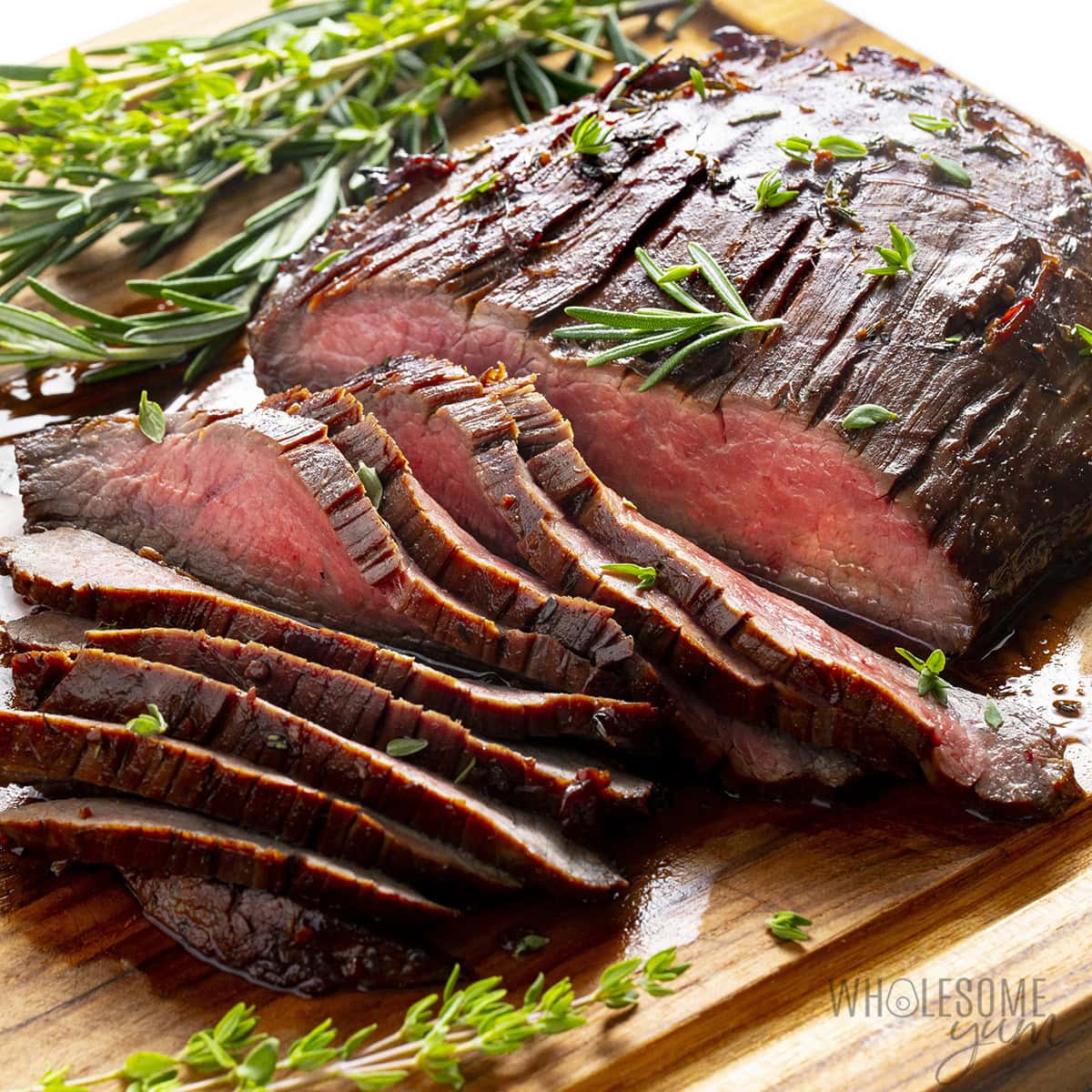 Grilled London broil sliced on a cutting board.